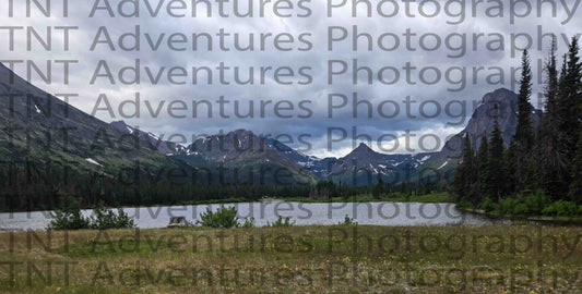 Lake surrounded by mountains under a cloudy sky