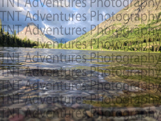 Reflective water surface with a mountain and sky reflection